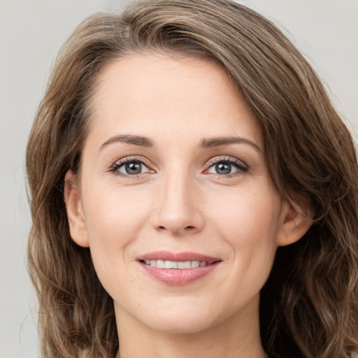 Joyful white young-adult female with long  brown hair and green eyes