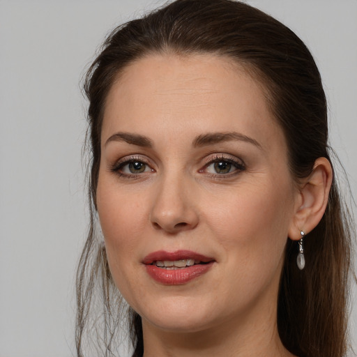 Joyful white young-adult female with long  brown hair and grey eyes