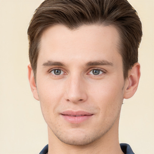 Joyful white young-adult male with short  brown hair and grey eyes