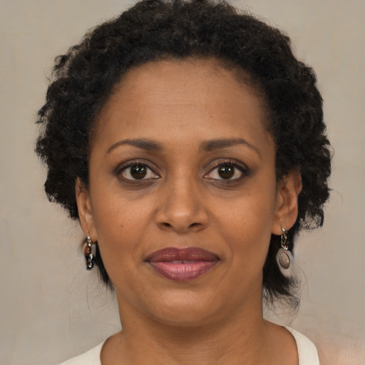 Joyful black adult female with short  brown hair and brown eyes