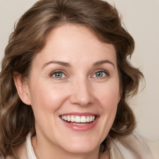 Joyful white young-adult female with medium  brown hair and blue eyes