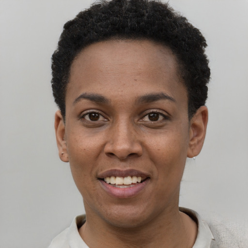 Joyful black young-adult female with short  black hair and brown eyes