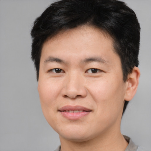 Joyful asian young-adult male with short  brown hair and brown eyes