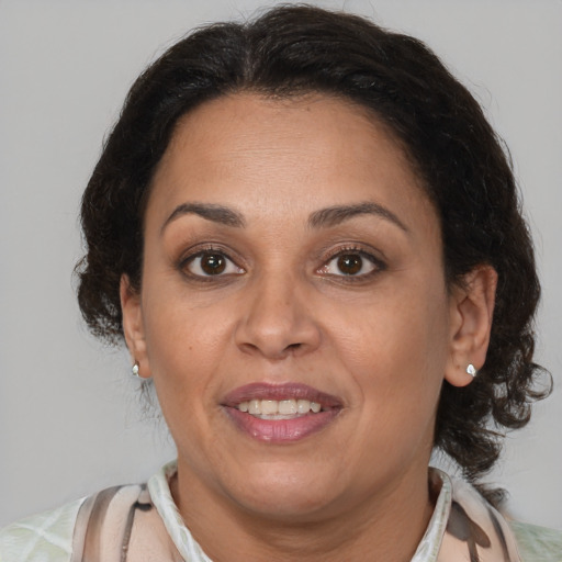 Joyful latino adult female with medium  brown hair and brown eyes
