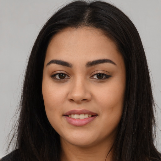Joyful latino young-adult female with long  brown hair and brown eyes
