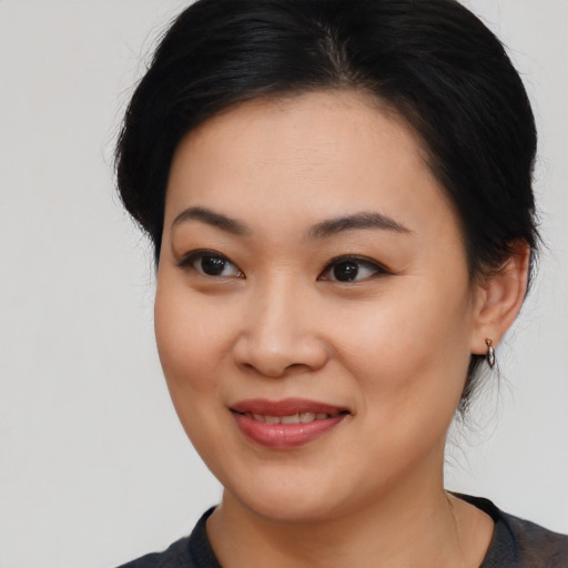 Joyful asian young-adult female with medium  black hair and brown eyes