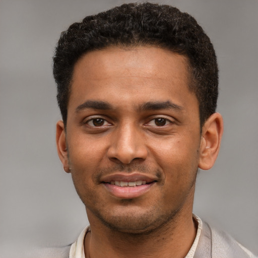 Joyful black young-adult male with short  brown hair and brown eyes