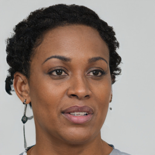 Joyful black adult female with short  brown hair and brown eyes