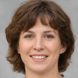 Joyful white young-adult female with medium  brown hair and green eyes