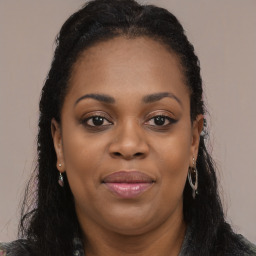 Joyful black young-adult female with long  black hair and brown eyes