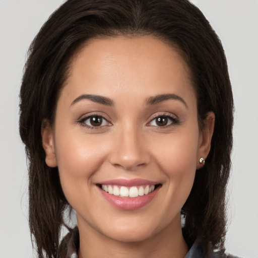 Joyful white young-adult female with long  brown hair and brown eyes