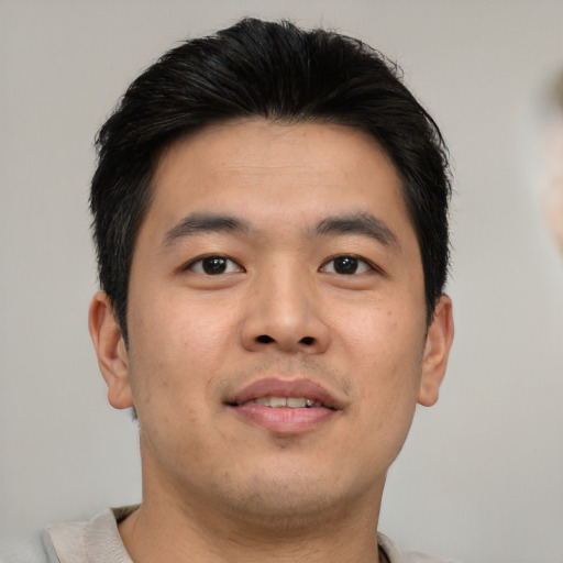 Joyful asian young-adult male with short  brown hair and brown eyes