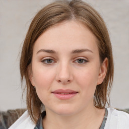 Joyful white young-adult female with medium  brown hair and grey eyes