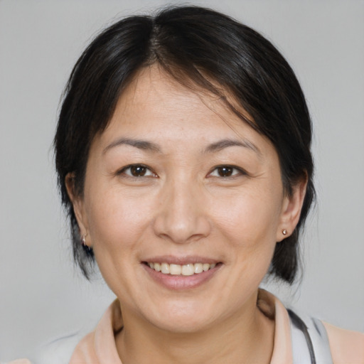 Joyful asian adult female with medium  brown hair and brown eyes
