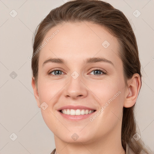 Joyful white young-adult female with medium  brown hair and grey eyes