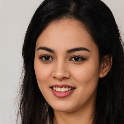 Joyful latino young-adult female with long  black hair and brown eyes