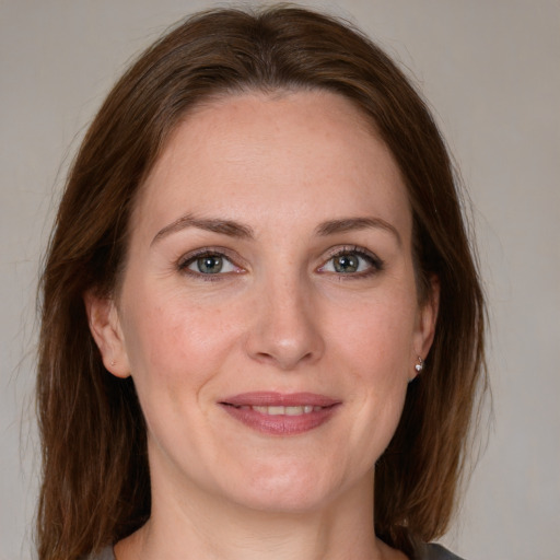 Joyful white adult female with medium  brown hair and grey eyes