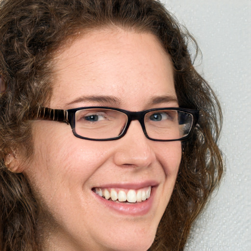 Joyful white adult female with long  brown hair and blue eyes