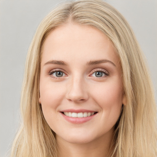 Joyful white young-adult female with long  brown hair and blue eyes