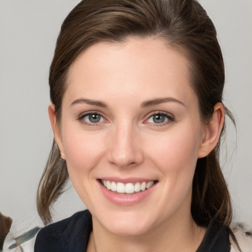 Joyful white young-adult female with medium  brown hair and blue eyes