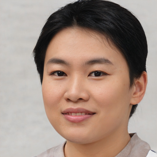 Joyful asian young-adult female with short  brown hair and brown eyes