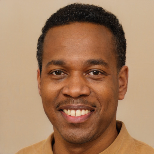 Joyful black young-adult male with short  black hair and brown eyes