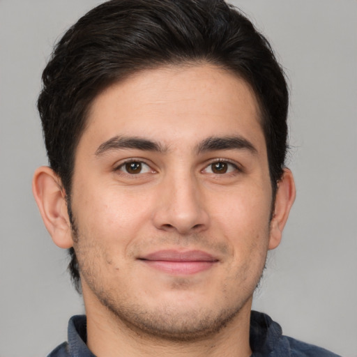 Joyful white young-adult male with short  brown hair and brown eyes