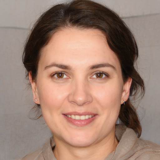 Joyful white adult female with medium  brown hair and brown eyes