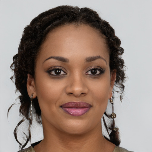 Joyful black young-adult female with long  brown hair and brown eyes