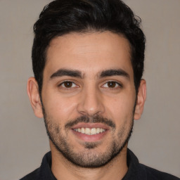 Joyful white young-adult male with short  black hair and brown eyes