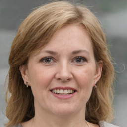 Joyful white adult female with medium  brown hair and grey eyes