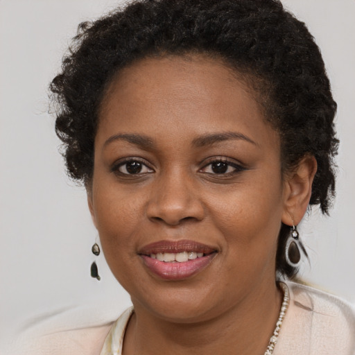 Joyful black young-adult female with short  brown hair and brown eyes