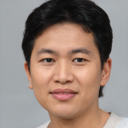 Joyful asian young-adult male with short  black hair and brown eyes