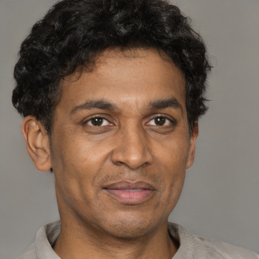Joyful latino adult male with short  brown hair and brown eyes