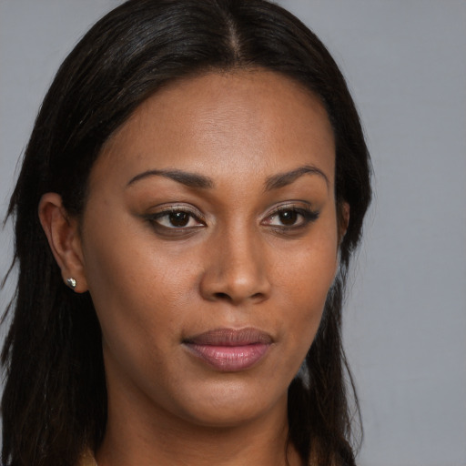 Joyful black young-adult female with long  brown hair and brown eyes