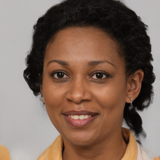 Joyful black adult female with long  brown hair and brown eyes