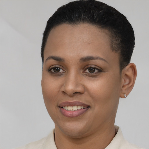 Joyful black young-adult female with short  black hair and brown eyes