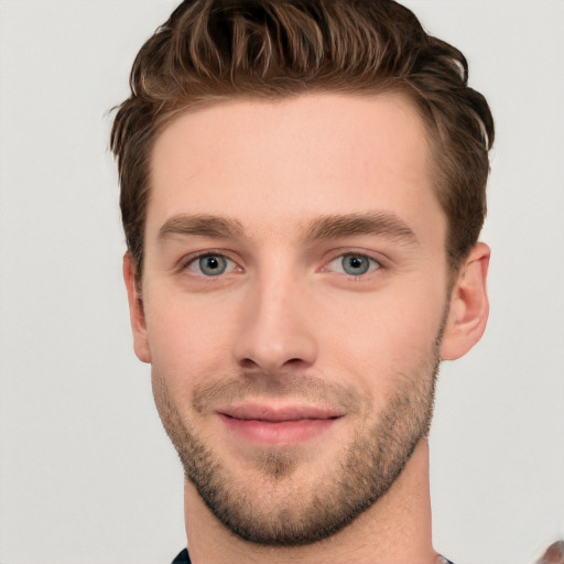 Joyful white young-adult male with short  brown hair and grey eyes