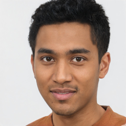 Joyful latino young-adult male with short  black hair and brown eyes