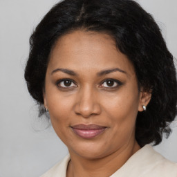 Joyful black adult female with medium  brown hair and brown eyes