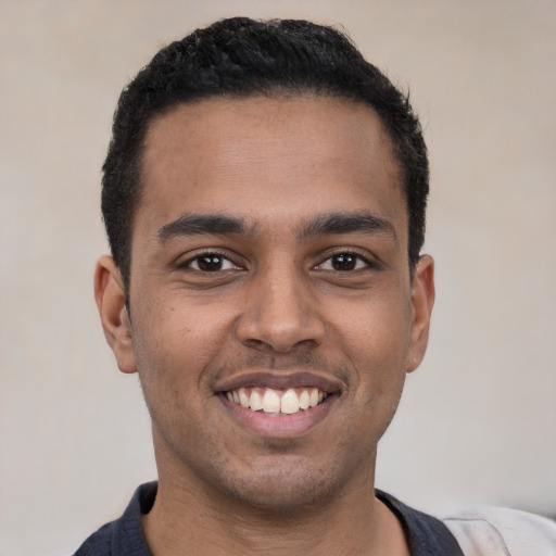 Joyful black young-adult male with short  black hair and brown eyes