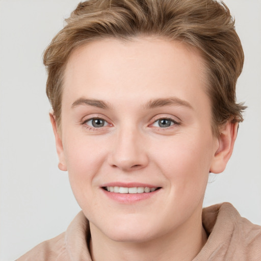 Joyful white young-adult female with short  brown hair and blue eyes