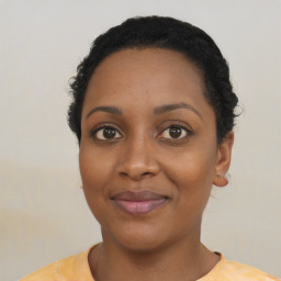 Joyful black young-adult female with short  black hair and brown eyes