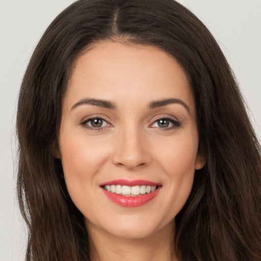 Joyful white young-adult female with long  brown hair and brown eyes