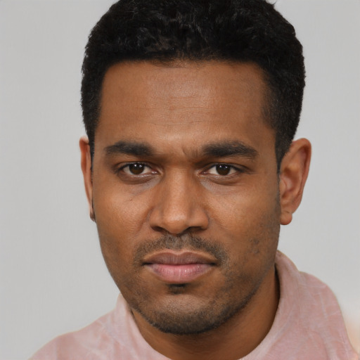 Joyful black young-adult male with short  black hair and brown eyes