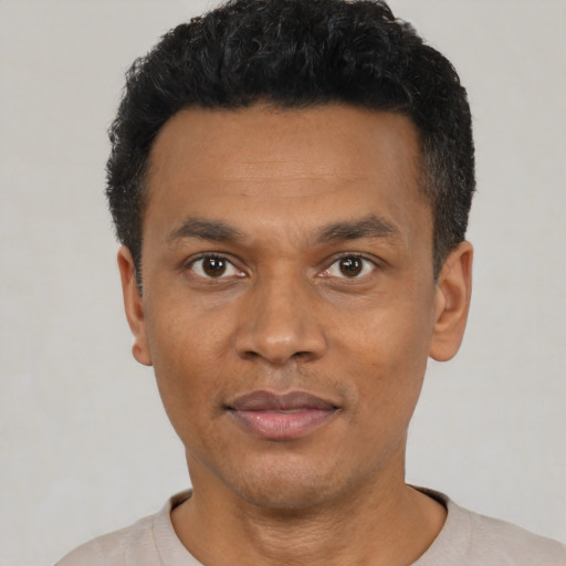 Joyful black adult male with short  black hair and brown eyes