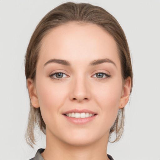 Joyful white young-adult female with medium  brown hair and grey eyes