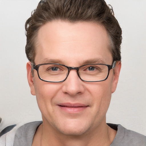 Joyful white adult male with short  brown hair and grey eyes