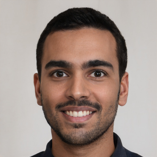 Joyful latino young-adult male with short  black hair and brown eyes