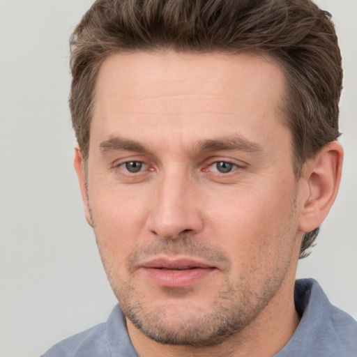 Joyful white young-adult male with short  brown hair and grey eyes